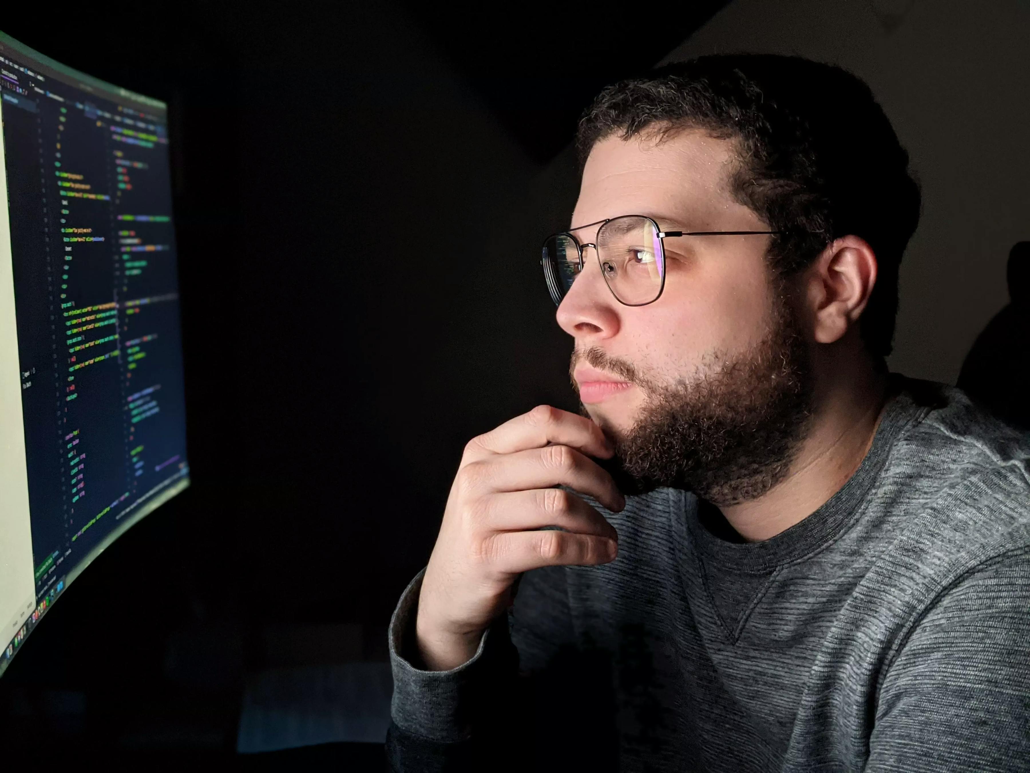 Picture of Dak at his computer in deep thought.